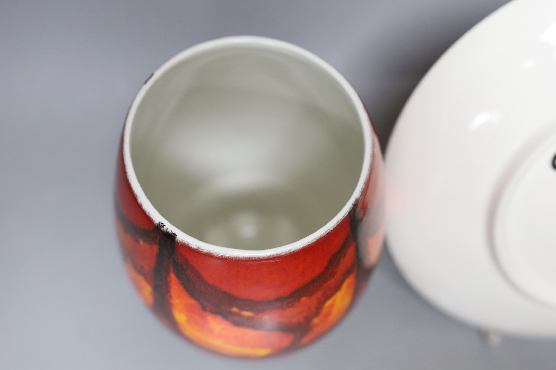 A Poole pottery orange and red abstract vase and plate, 20cm diameter